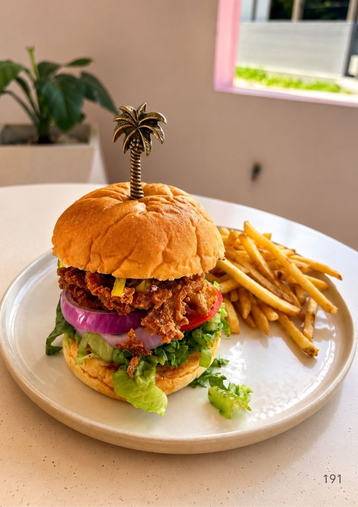 A fried chicken burger with fries at KYND Uluwatu in Bali