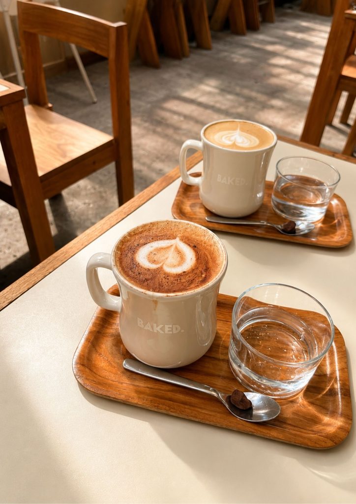 A latte served on a timber tray at BAKED. bakery in Canggu, Bali