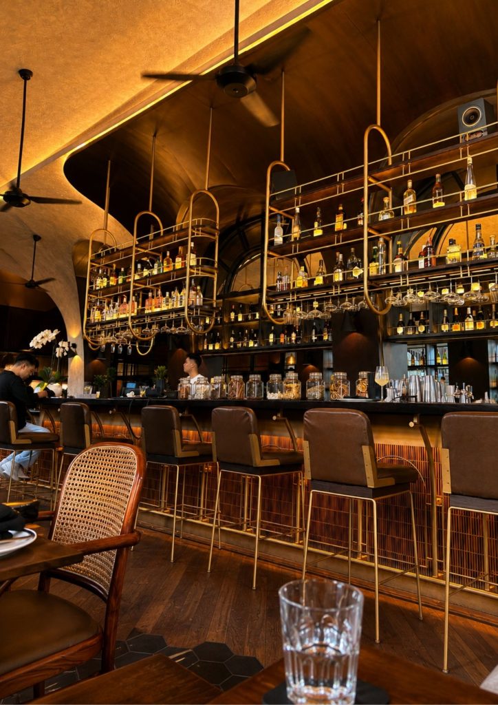 The warm-lit bar and rattan stools inside Buzo on Jalan Kayu Aya in Seminyak, Bali