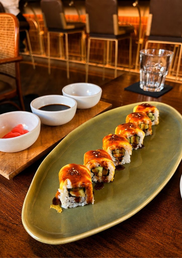 A sushi roll on a green plate at the bar at Buzo in Seminyak, Bali