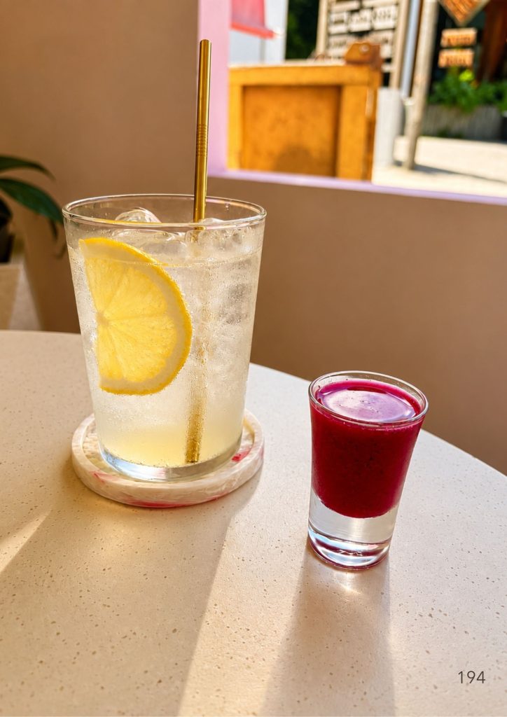 House lemonade and a beetroot shot on the table at KYND Uluwatu, Bali