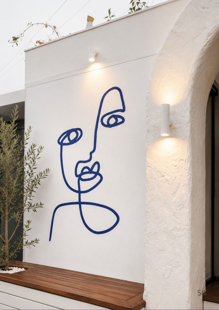 A whitewashed Gold Coast cafe interior with a blue line drawing mural, timber bench and an olive tree