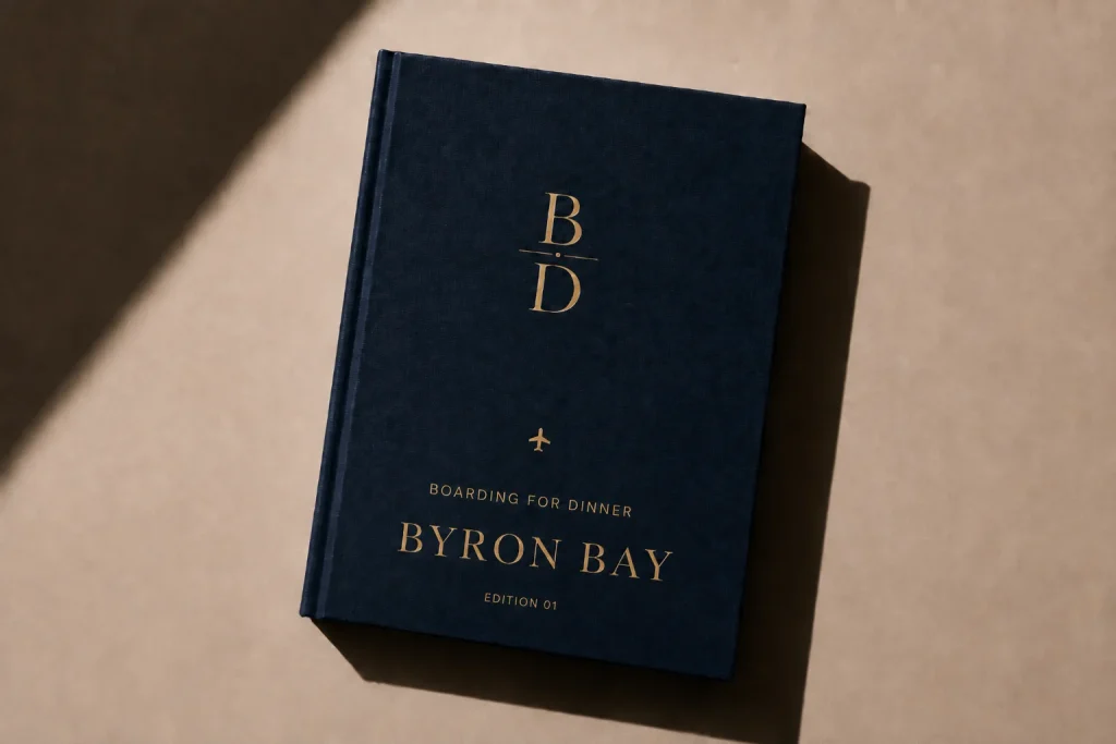 The Byron Bay Food Guide from Boarding for Dinner, a navy hardcover with gold foil lettering