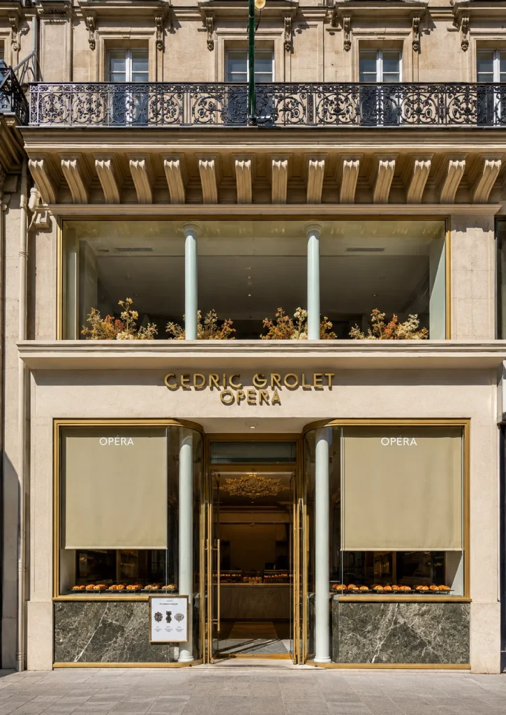 Parisian restaurant façade with cream awnings and wrought-iron balconies