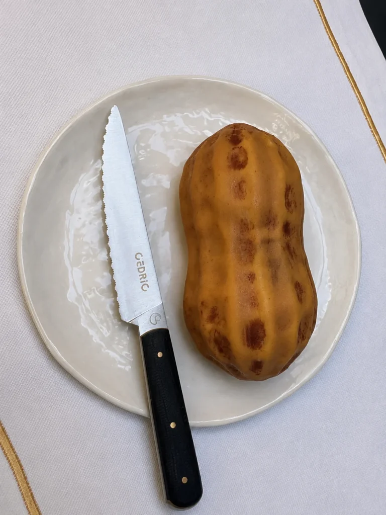 Golden baked pastry on a white plate beside a steak knife