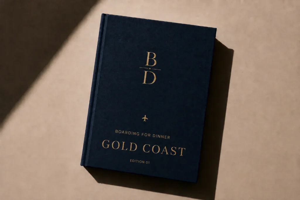 Gold Coast Food Guide digital edition cover from Boarding for Dinner, a navy book with gold foil lettering