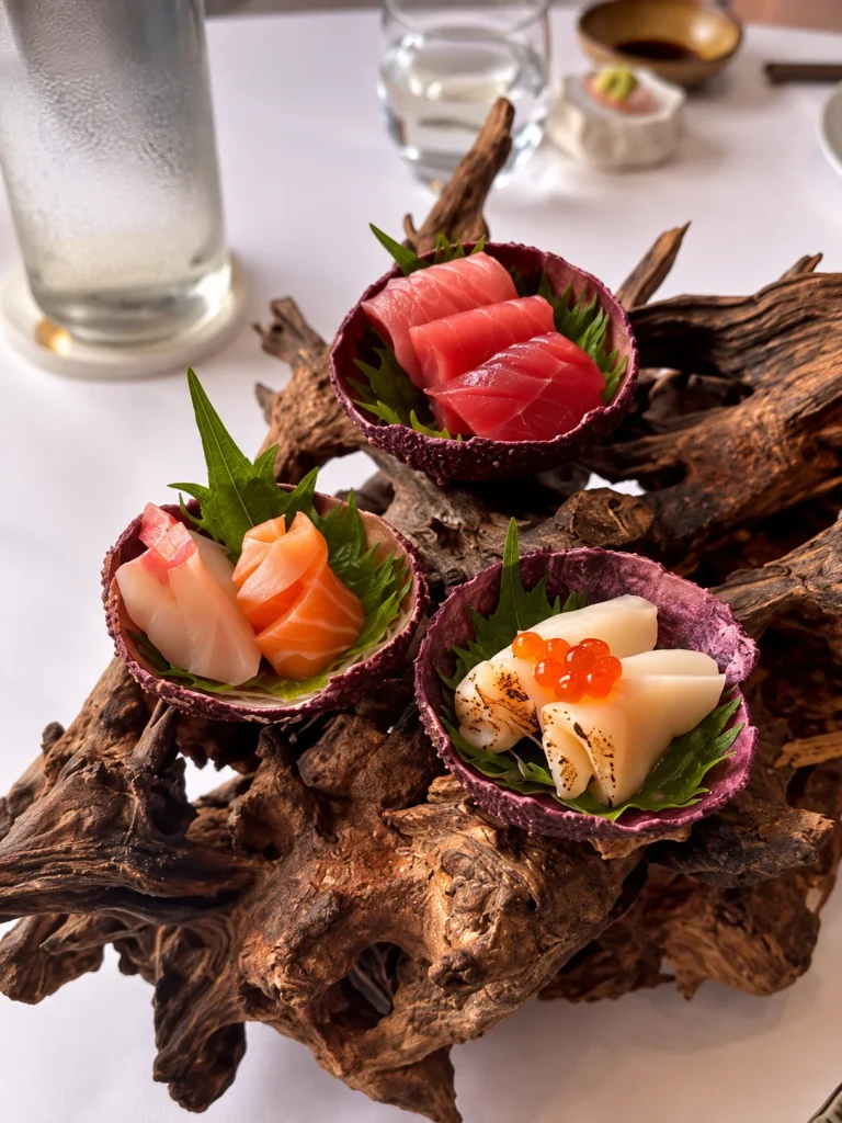 Sashimi platter with tuna, salmon and roe served in shells on driftwood