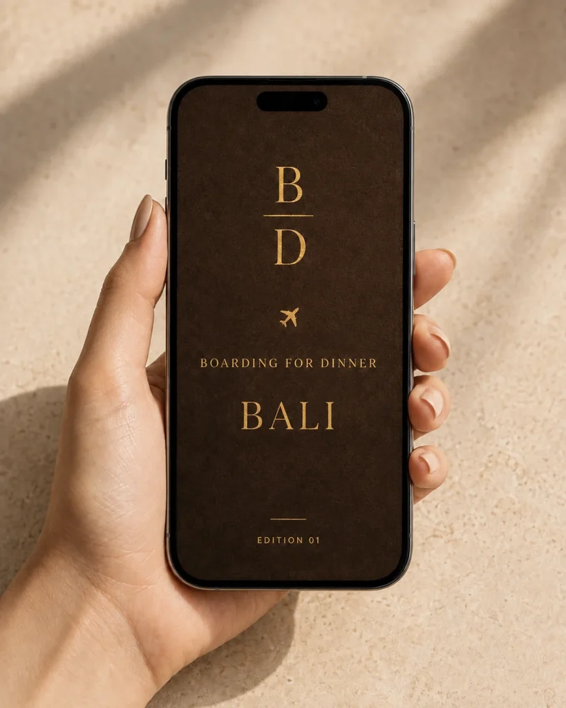 A hand holding a phone showing the Bali Food Guide cover