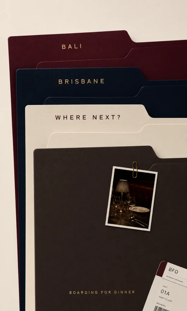 A "Where Next?" travel dossier with a restaurant table Polaroid and a Boarding for Dinner ticket, symbolising planning your next city food guide