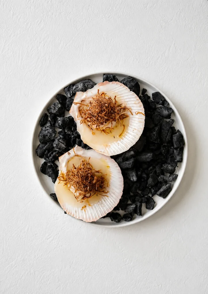 Torched scallops served on black stones at a Byron Bay restaurant
