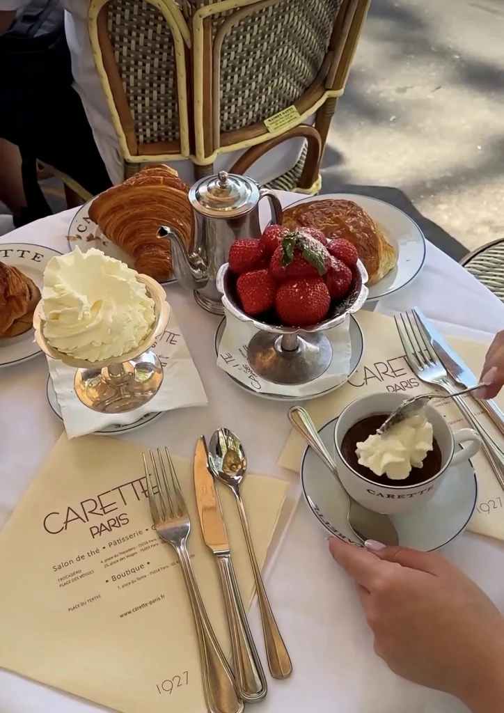 Breakfast table with croissants, strawberries and a Carette menu card